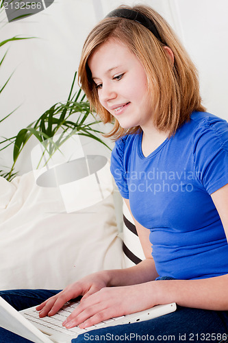 Image of young teenager girl with laptop smilig