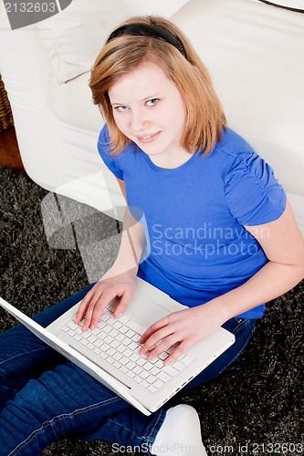 Image of young teenager girl with laptop smilig