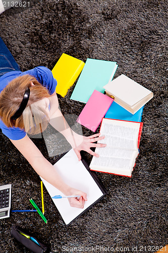 Image of happy teenager girl doing homework 