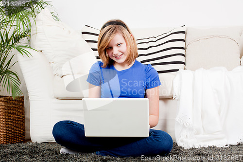 Image of young teenager girl with laptop smilig