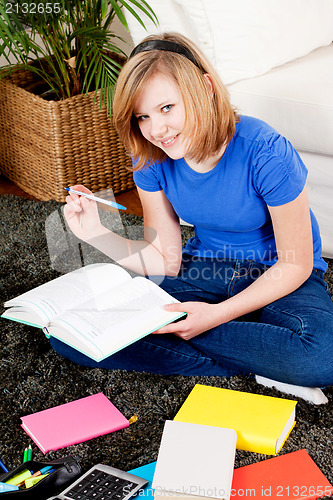Image of happy teenager girl doing homework 