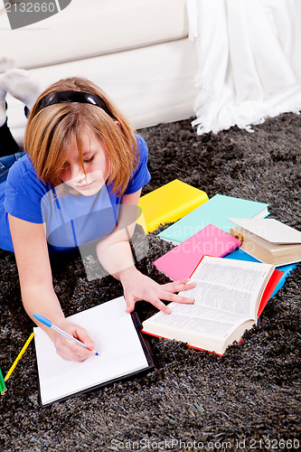 Image of happy teenager girl doing homework 
