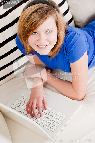 Image of young teenager girl with laptop smilig