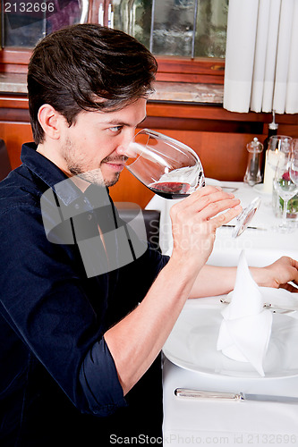 Image of couple drinking red wine in restaurant