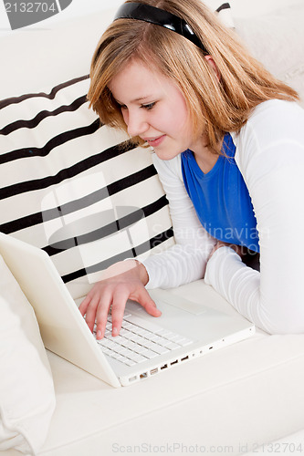 Image of young teenager girl with laptop smilig