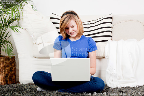 Image of young teenager girl with laptop smilig