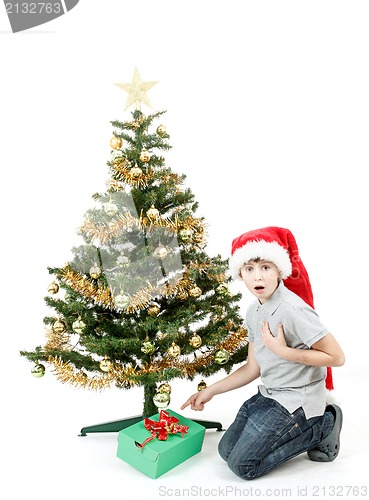 Image of happy boy in santa hat surprised by christmas present