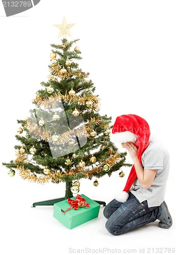 Image of happy boy in santa hat surprised by christmas present