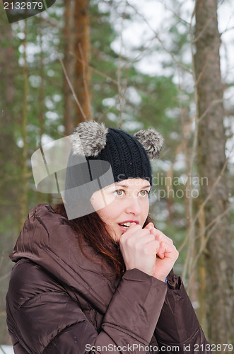 Image of The young woman heats the frozen hands in winter park