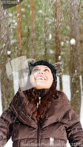 Image of Cute young woman playing with snow  outdoors