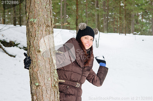 Image of Cute young woman playing with snow  outdoors