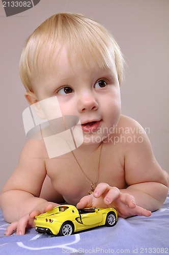 Image of toddler boy playing with a toy car