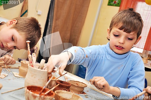 Image of children shaping clay in pottery studio