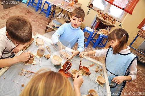 Image of 	group of children shaping clay in pottery studio