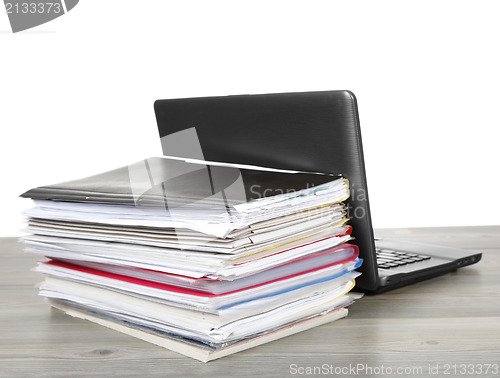 Image of Many files and a computer on a desk 