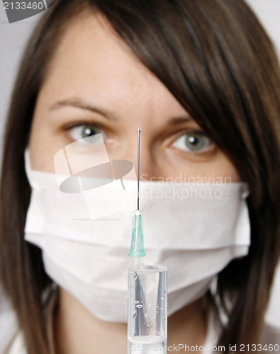 Image of Nurse in mask with syringe 
