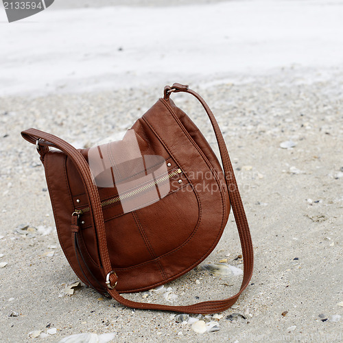 Image of Brown purse on sand 