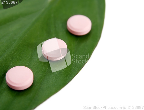 Image of Natural pills and a green leaf 