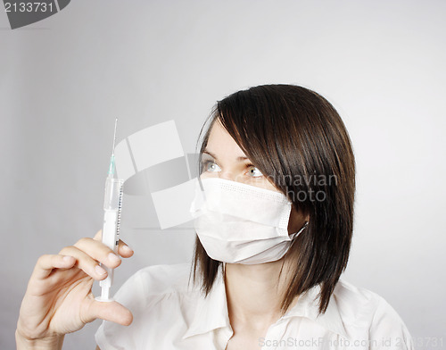 Image of Nurse in mask with syringe 