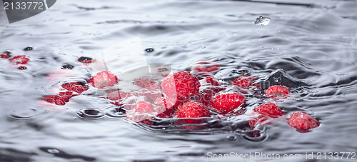 Image of Red Raspberries Dropped into Water with Splash