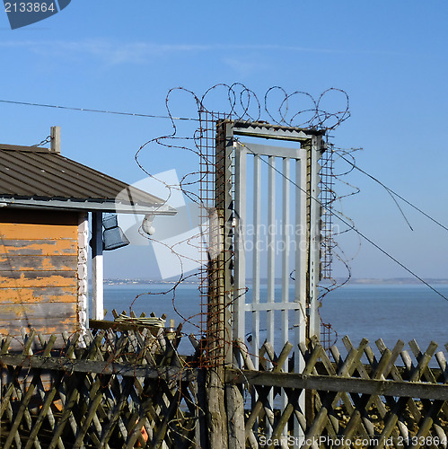 Image of Barbed wire around a closed gate.