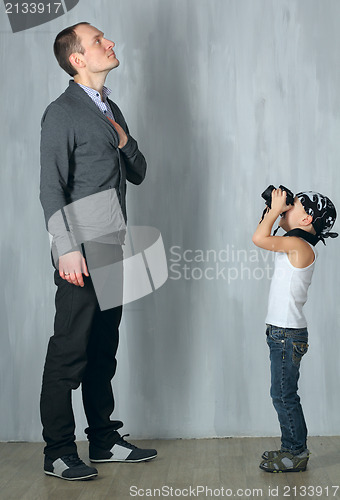 Image of Little boy takes a photo of a man