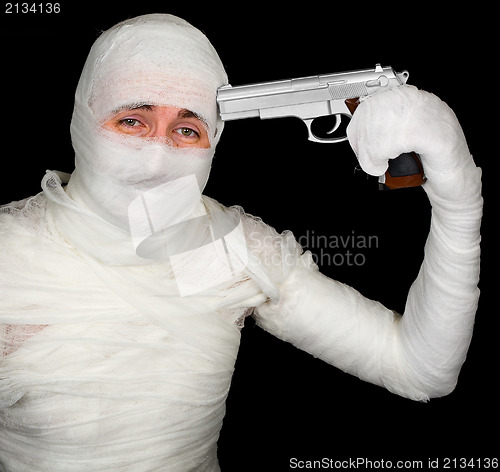 Image of Completely bandaged man with gun - suicide