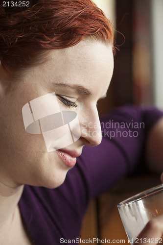 Image of Young Woman with Beautiful Auburn Hair Drinking Water