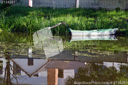 Image of boat moored river shore house reflections water 