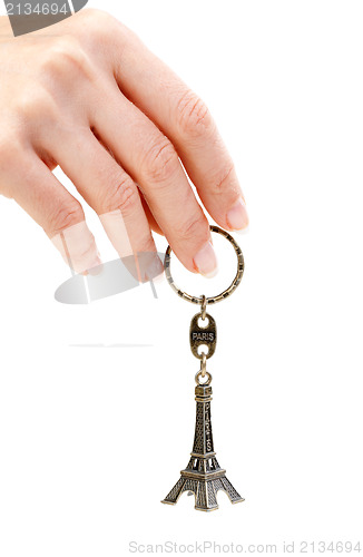 Image of Hand holding small Eiffel Tower statuette