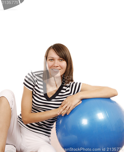 Image of Young woman with gym ball