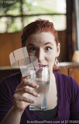 Image of Young Woman with Beautiful Auburn Hair Drinking Water