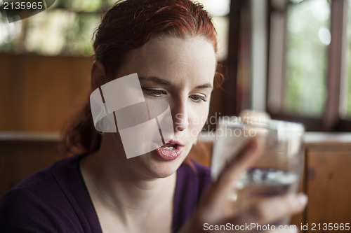 Image of Young Woman with Beautiful Auburn Hair Drinking Water