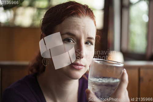 Image of Young Woman with Beautiful Auburn Hair Drinking Water