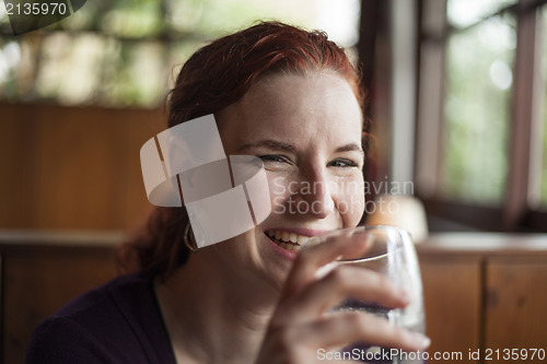 Image of Young Woman with Beautiful Auburn Hair Drinking Water