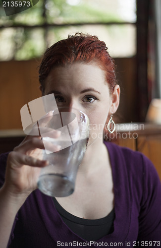 Image of Young Woman with Beautiful Auburn Hair Drinking Water