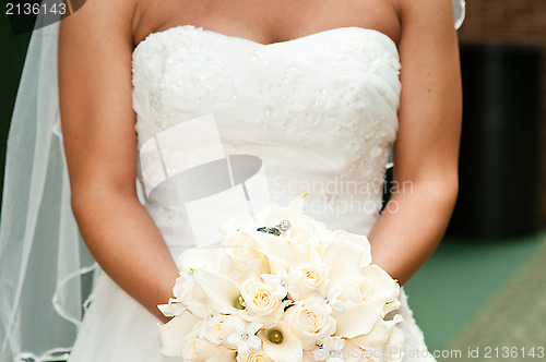 Image of Bride holding bouquet with wedding rings.