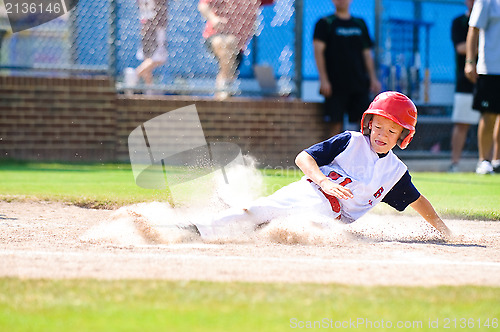 Image of Little league baseball player sliding home.