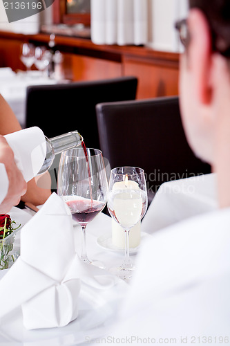 Image of couple drinking red wine in restaurant