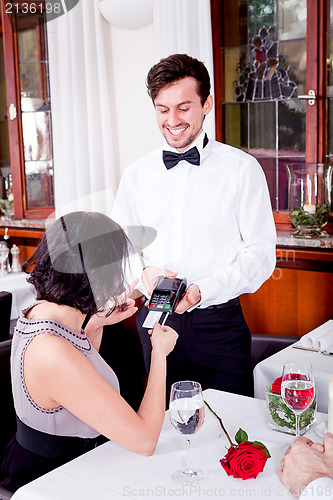 Image of dinner in restaurant man and woman pay by credit card