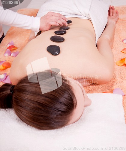 Image of young attractive woman get hot stone massage 