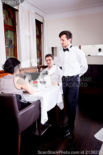 Image of couple drinking red wine in restaurant