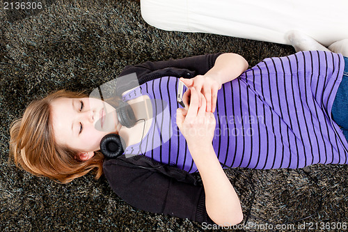 Image of happy teenager girl listening to music