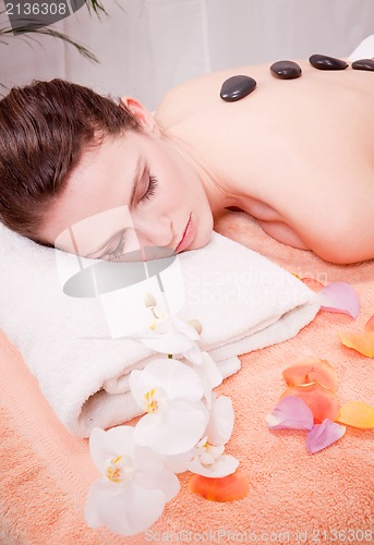 Image of young attractive woman get hot stone massage 