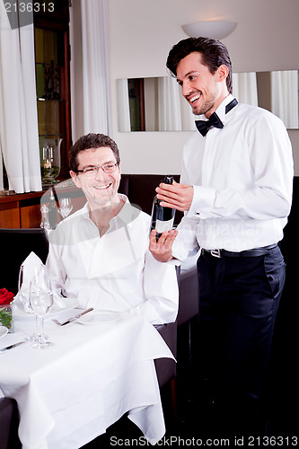 Image of couple drinking red wine in restaurant