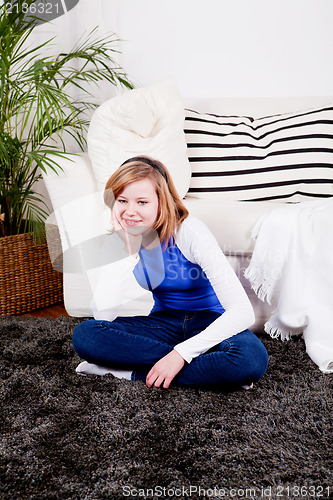 Image of happy teenager girl smiling sitting on couch 