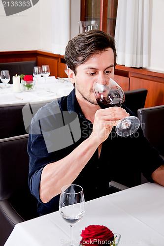 Image of couple drinking red wine in restaurant