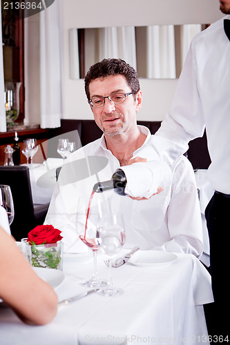 Image of couple drinking red wine in restaurant