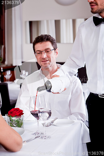 Image of couple drinking red wine in restaurant