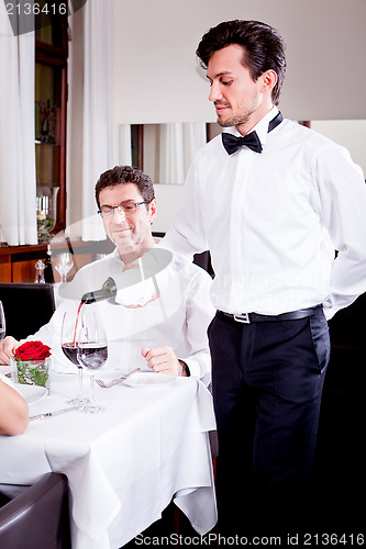 Image of couple drinking red wine in restaurant